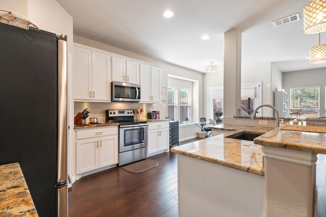 kitchen featuring white cabinets, appliances with stainless steel finishes, and a healthy amount of sunlight