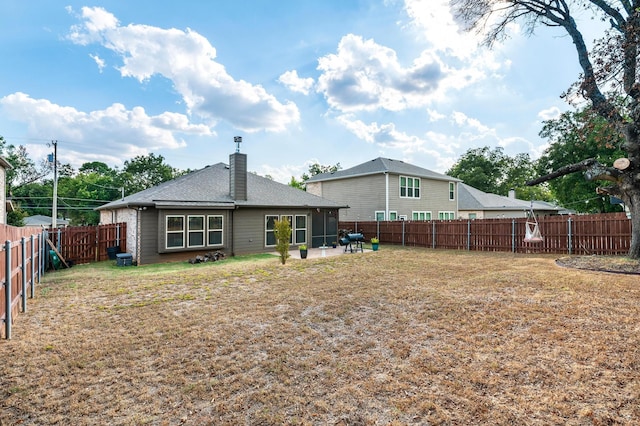 back of house with a lawn and a patio area