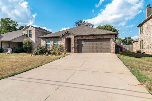 view of front of house with a garage, central AC unit, and a front yard