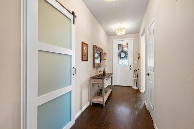 foyer with dark wood-type flooring and a barn door