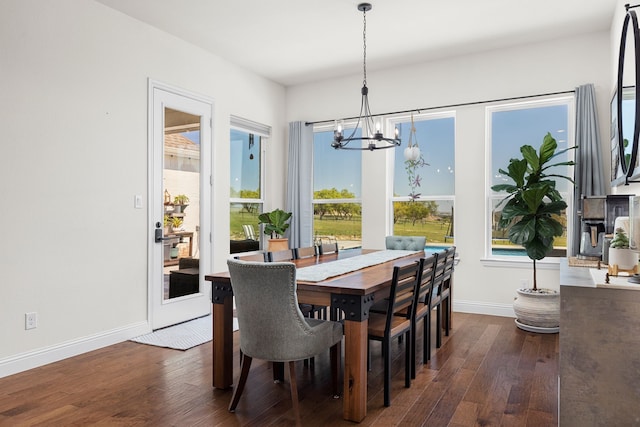 dining room with dark hardwood / wood-style floors and a notable chandelier