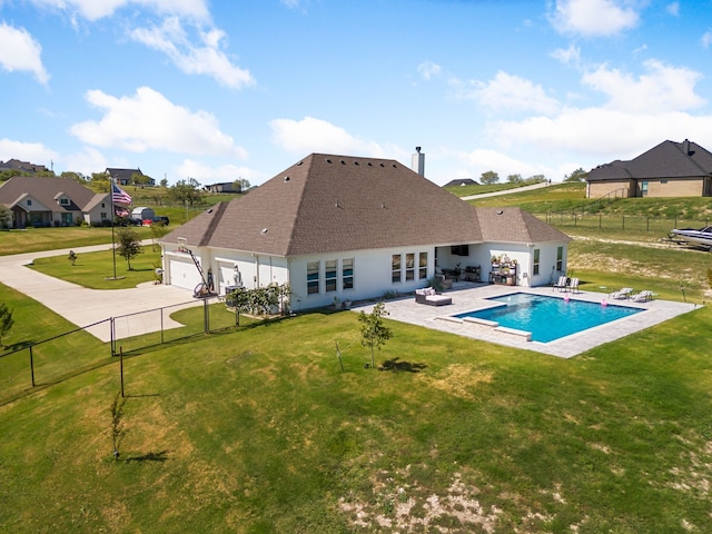 rear view of house with a fenced in pool, a lawn, and a patio