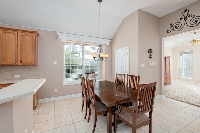 dining space with light tile patterned flooring, ceiling fan with notable chandelier, and lofted ceiling