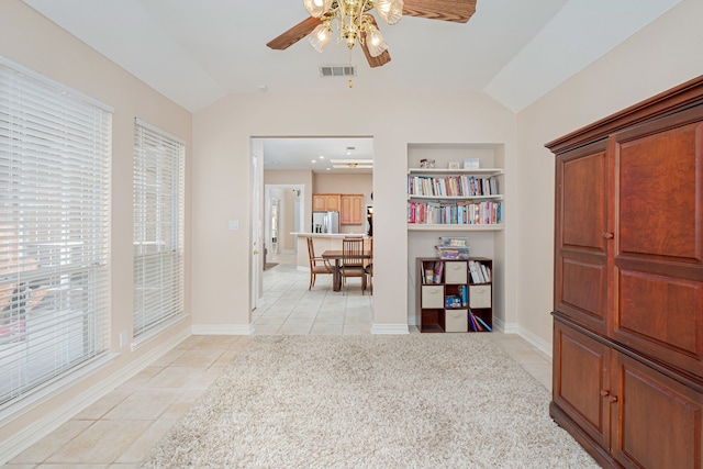 interior space with lofted ceiling, light tile patterned flooring, and built in features