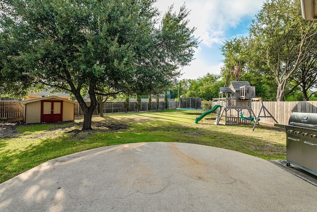 view of yard with a playground, a storage unit, and a patio area