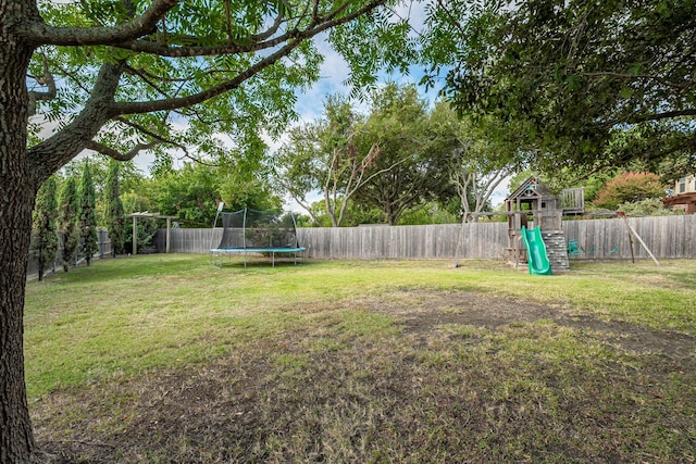 view of yard with a trampoline and a playground