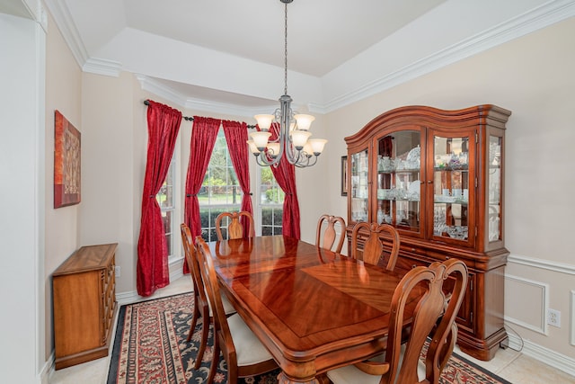 tiled dining room with ornamental molding, a chandelier, and a raised ceiling