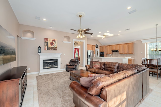 living room with ceiling fan with notable chandelier and light tile patterned floors