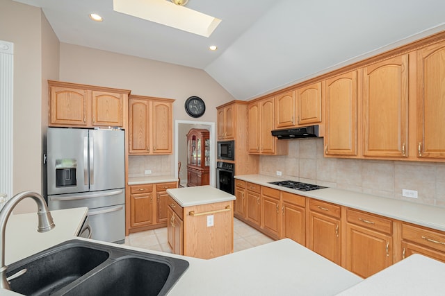 kitchen with vaulted ceiling with skylight, a center island, tasteful backsplash, sink, and black appliances