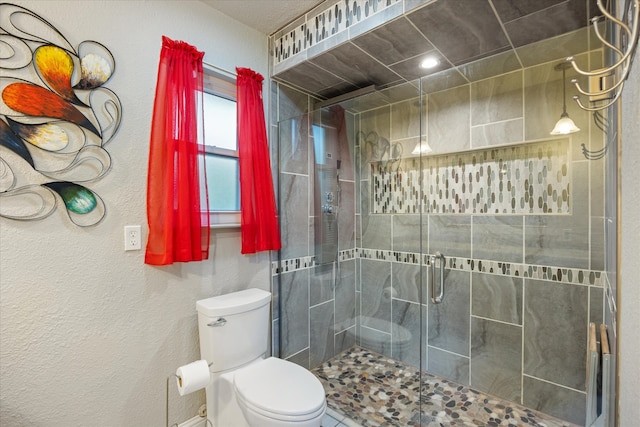 bathroom with toilet and a shower with shower door