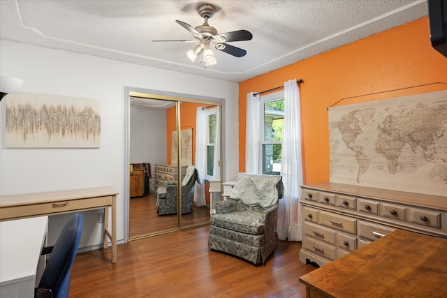 sitting room with a textured ceiling, dark hardwood / wood-style flooring, and ceiling fan