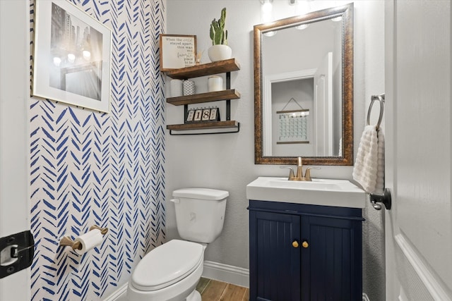 bathroom with hardwood / wood-style floors, vanity, and toilet