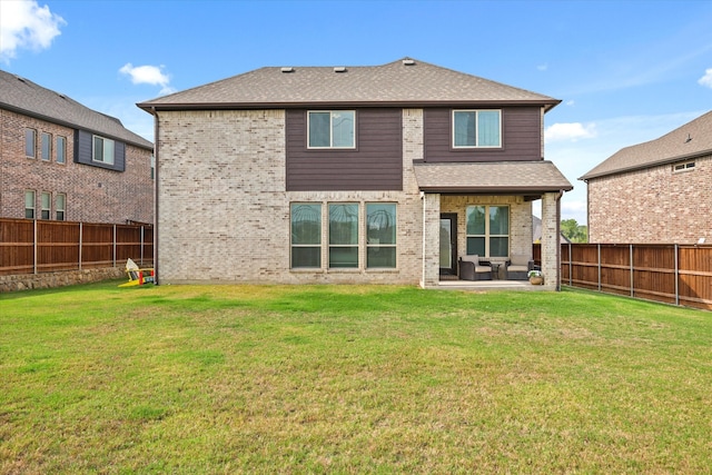 back of property with a lawn and a patio