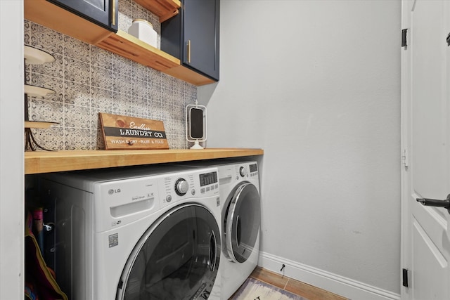 laundry area featuring washer and clothes dryer, tile patterned floors, and cabinets