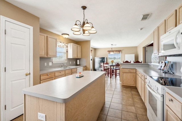 kitchen with a chandelier, a center island, white appliances, and decorative light fixtures