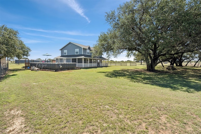 view of yard featuring a sunroom and a pool