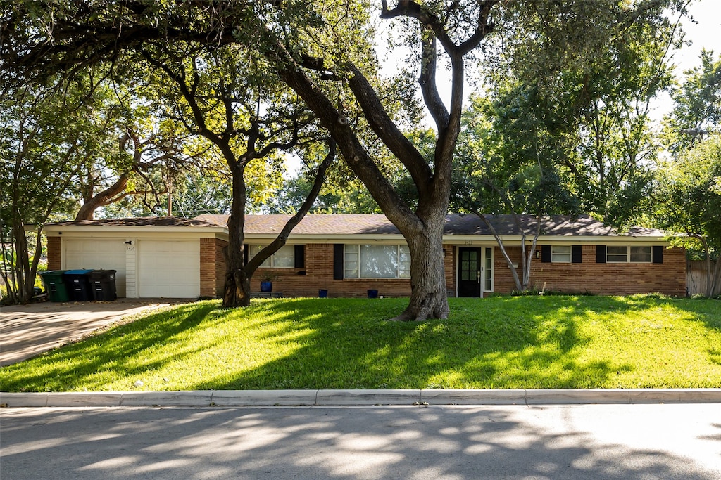 ranch-style house with a front yard and a garage