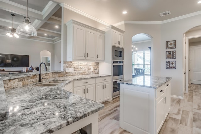 kitchen with white cabinets, beamed ceiling, sink, coffered ceiling, and light stone countertops