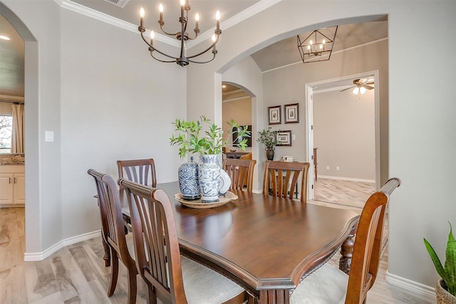dining room featuring baseboards, arched walkways, ceiling fan with notable chandelier, and ornamental molding