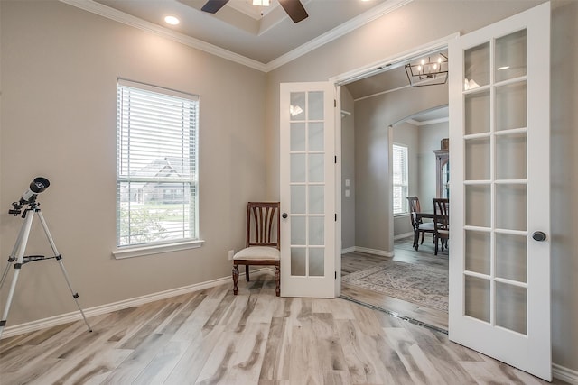 sitting room with ceiling fan, light wood-type flooring, french doors, and ornamental molding