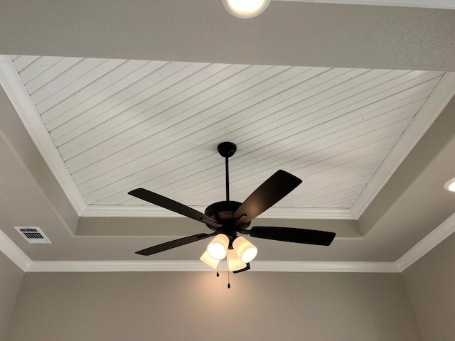 interior details featuring a raised ceiling, ornamental molding, and ceiling fan