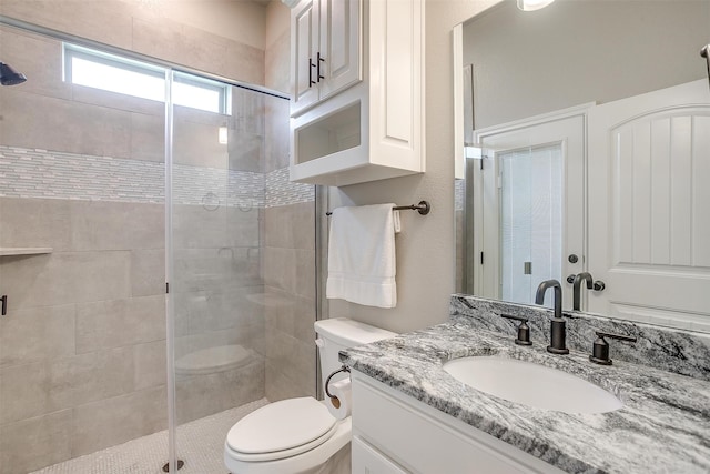 bathroom featuring vanity, toilet, and an enclosed shower