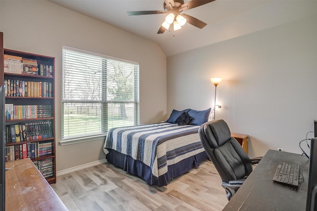 bedroom with vaulted ceiling, multiple windows, light wood-style flooring, and baseboards