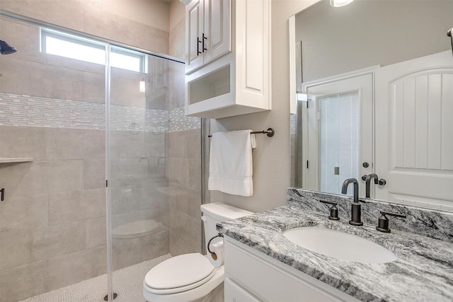 bathroom featuring vanity, toilet, and a stall shower