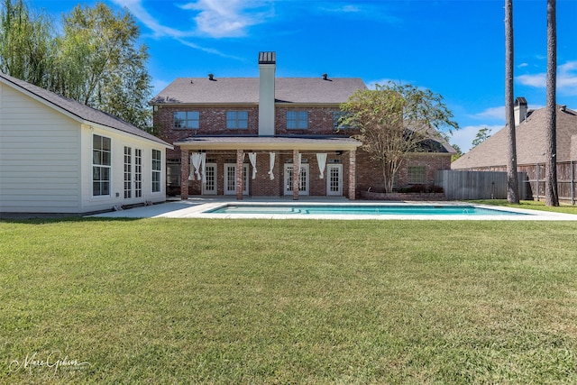 back of house with french doors, a fenced in pool, a lawn, and a patio area