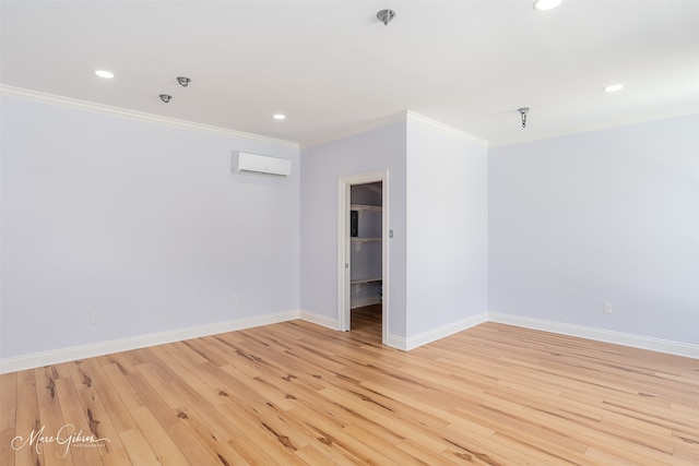 spare room with light hardwood / wood-style floors, crown molding, and a wall mounted air conditioner