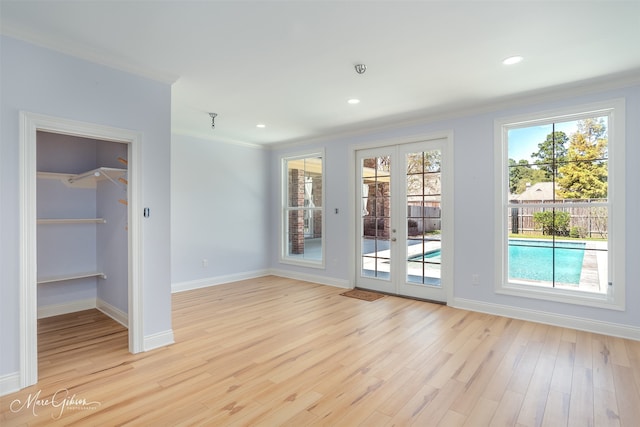 doorway to outside with light wood-type flooring, crown molding, and french doors