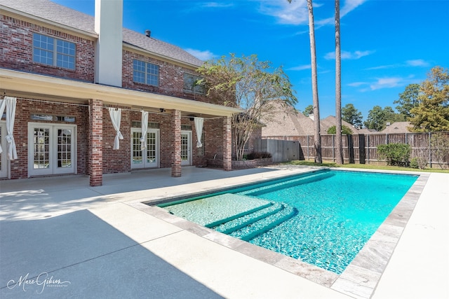 view of pool with a patio, ceiling fan, and french doors