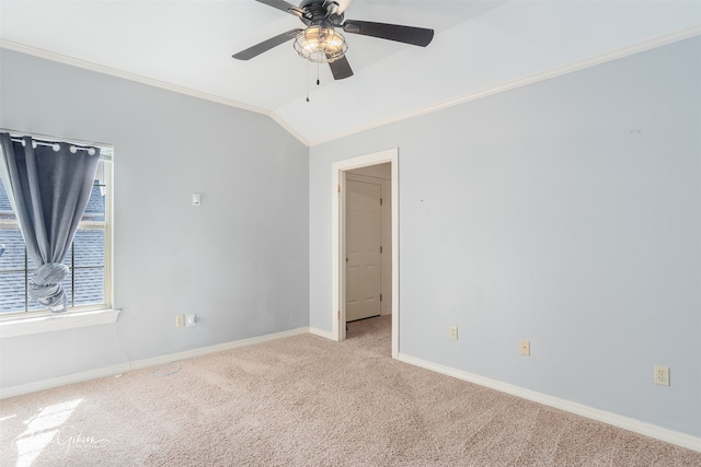 empty room featuring light carpet, lofted ceiling, crown molding, and ceiling fan