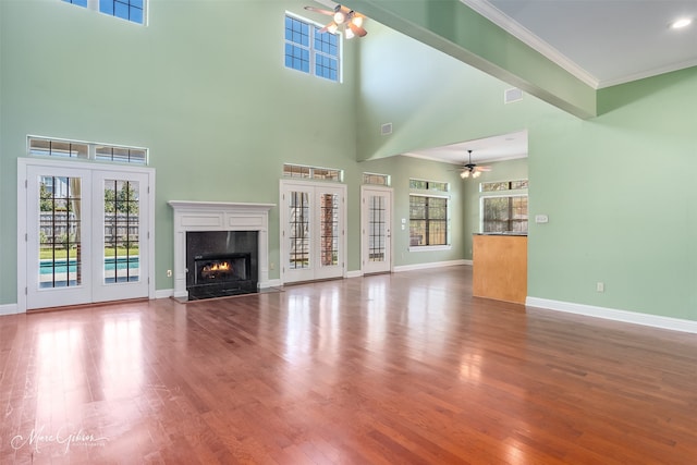 unfurnished living room featuring wood-type flooring, plenty of natural light, and a premium fireplace