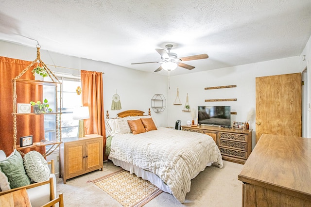 carpeted bedroom with ceiling fan and a textured ceiling