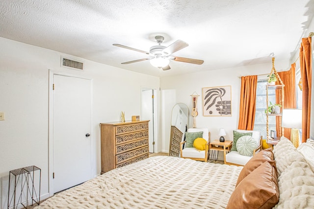 bedroom featuring ceiling fan and a textured ceiling