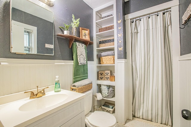 bathroom with curtained shower, vanity, and toilet