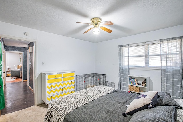 bedroom featuring carpet, ceiling fan, and a textured ceiling