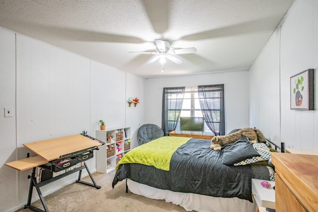 bedroom with ceiling fan, light colored carpet, and a textured ceiling