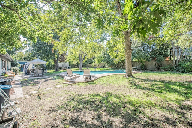 view of yard with a gazebo, a patio, a trampoline, and a fenced in pool