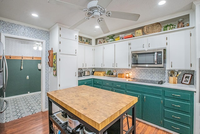 kitchen featuring stainless steel appliances, green cabinets, light hardwood / wood-style flooring, white cabinets, and ornamental molding