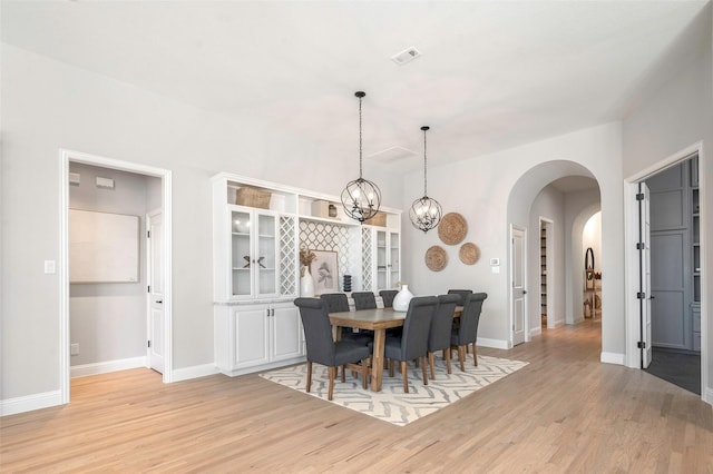 dining space featuring light hardwood / wood-style flooring and a chandelier