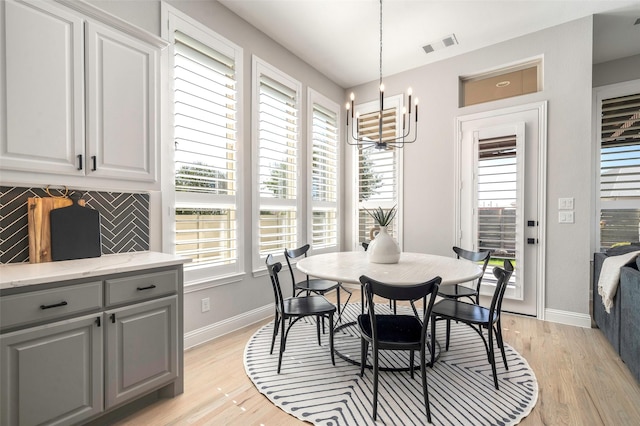 dining area with a notable chandelier and light hardwood / wood-style flooring