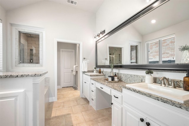 bathroom featuring tile patterned flooring, vanity, and lofted ceiling