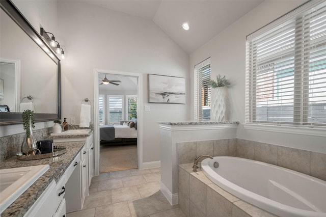 bathroom featuring ceiling fan, tile patterned floors, tiled tub, lofted ceiling, and vanity