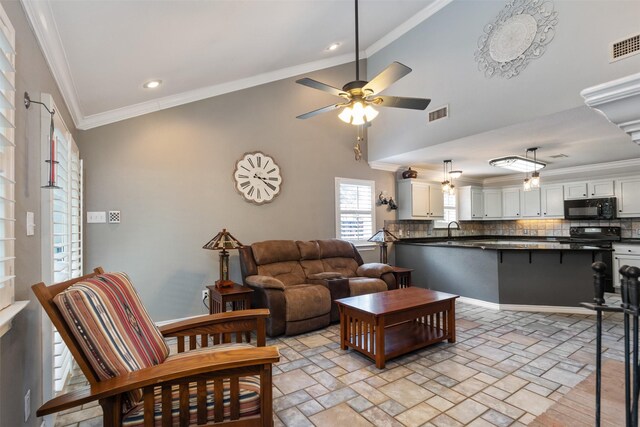 living room with ceiling fan, crown molding, lofted ceiling, and a fireplace