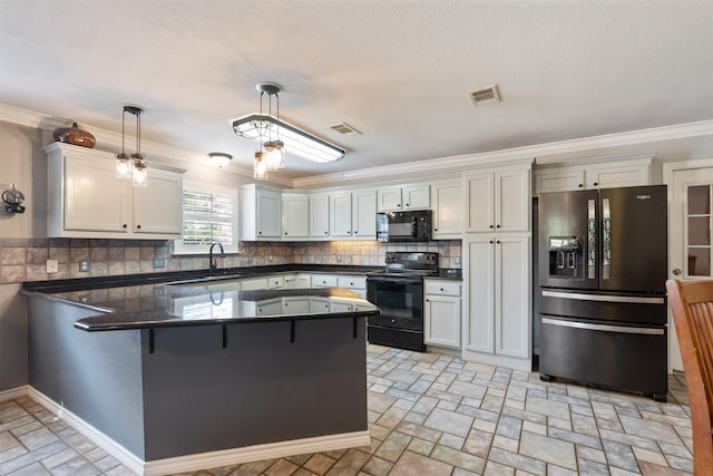 kitchen featuring kitchen peninsula, black appliances, pendant lighting, and decorative backsplash