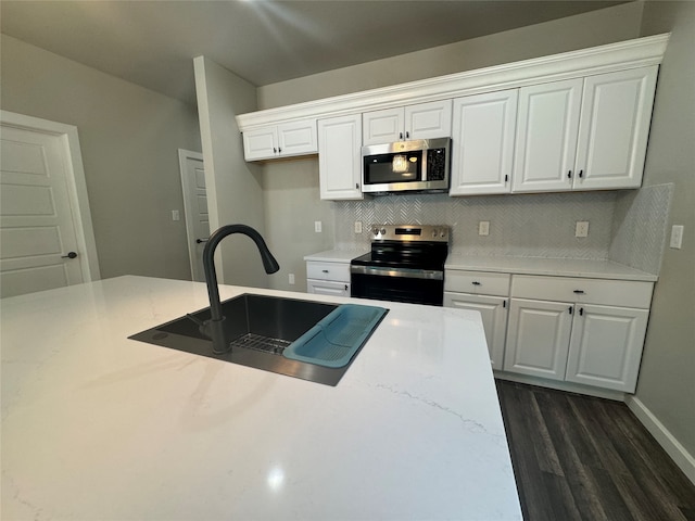 kitchen with stainless steel appliances, dark hardwood / wood-style flooring, and white cabinetry