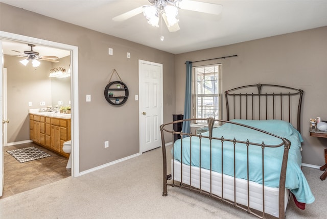 carpeted bedroom with ensuite bath, ceiling fan, and sink