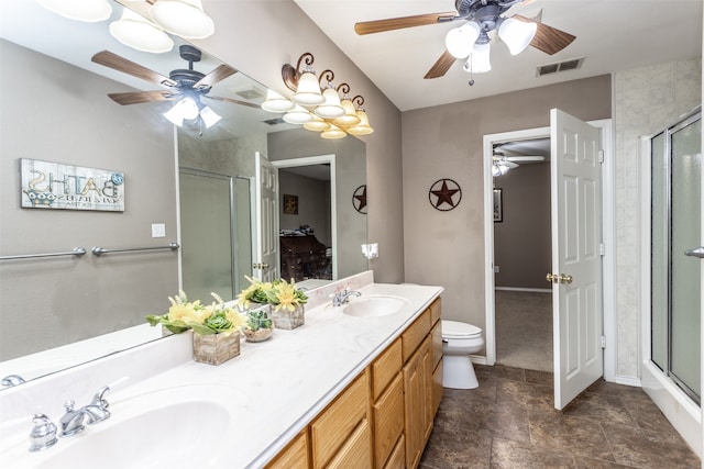 bathroom featuring vanity, toilet, ceiling fan, and an enclosed shower